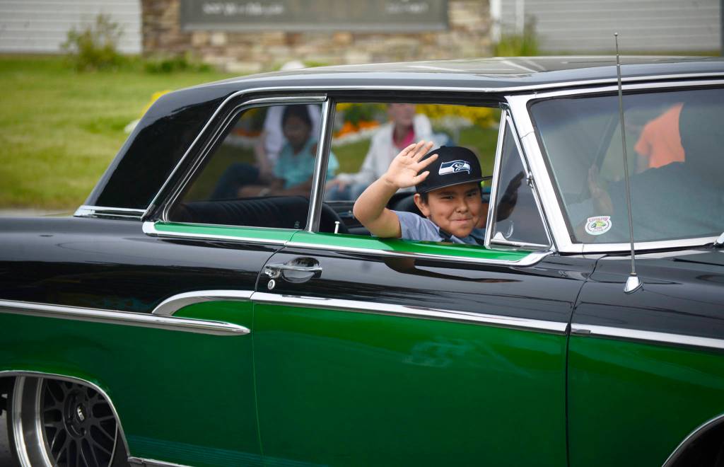 A participant in classic car club Kaknu Kruzers display in the Progress Days parade waves to spectators on Saturday, July 28, 2018 in Soldotna, Alaska. The parade kicks off the weekend-long event celebrating Soldotnas history, with a market on Saturday and Sunday in Soldotna Creek Park and a concert Saturday night followed by a free community barbecue Sunday. (Photo by Elizabeth Earl/Peninsula Clarion)