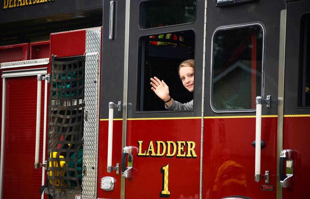 A participant in Central Emergency Services float in the Progress Days parade waves to spectators on Saturday, July 28, 2018 in Soldotna, Alaska. The parade kicks off the weekend-long event celebrating Soldotnas history, with a market on Saturday and Sunday in Soldotna Creek Park and a concert Saturday night followed by a free community barbecue Sunday. (Photo by Elizabeth Earl/Peninsula Clarion)