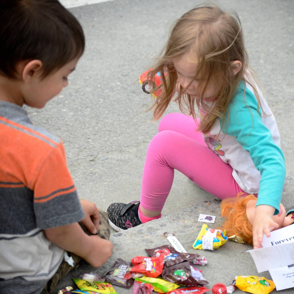 Ian Garay, 7, (left) and Stephanie Daigle, 3, (right), take stock of their candy stash collected from the Progress Days parade on Marydale Avenue on Saturday, July 28, 2018 in Soldotna, Alaska. The parade kicks off the weekend-long event celebrating Soldotnas history, with a market on Saturday and Sunday in Soldotna Creek Park and a concert Saturday night followed by a free community barbecue Sunday. (Photo by Elizabeth Earl/Peninsula Clarion)