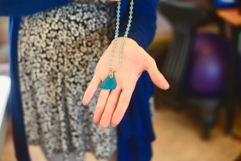 Jenna Bedford presents her first Alaska Sea Glass creation, which she wore as part of her Caring for the Kenai project in 2012, on Friday, July 27, 2018, in Nikiski, Alaska. (Photo by Victoria Petersen/Peninsula Clarion)