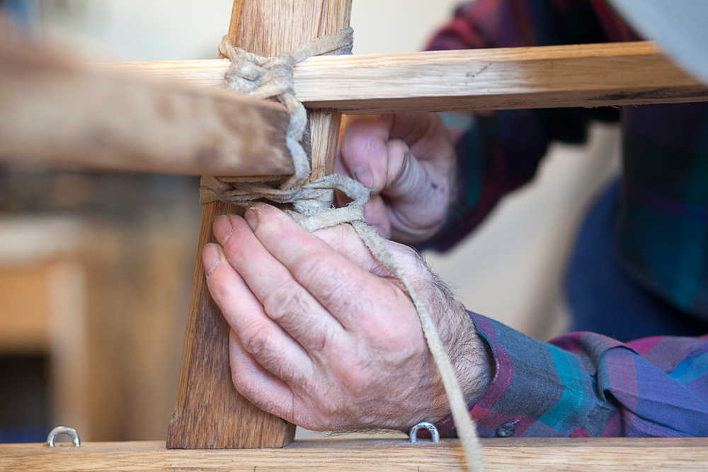 Photo by Rashah McChesney/Peninsula Clarion  Alan Perry lashes a portion of a wooden Iditarod sled he and two others are building for this year's race Thursday Feb. 20, 2014 in Kasilof, Alaska.