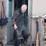 Photo by Rashah McChesney/Peninsula Clarion  Cliff Sisson, of Kasilof, walks out of his house with a braking mechanism for a wooden Iditarod sled he and two companions are building Thursday Feb. 20, 2014 in Kasilof, Alaska.
