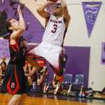 Photo by Rashah McChesney/Peninsula Clarion  Seldovia Sea Otter Calem Collier watches as Nikolaevsk Warrior Jaruby Nelson shoots during their game Friday March 7, 2014 at Skyview High School in Soldotna, Alaska.