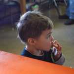 Photo by Rashah McChesney/Peninsula Clarion  Kash Bishop, 3, licks sugar off of his fingers as he eats a piece of fry bread Friday March 7, 2014 at Ft. Kenay in Kenai, Alaska.  Proceeds from the monthly "Fry Bread Fridays" benefit the Holy Assumption of the Virgin Mary Russian Orthodox Church.