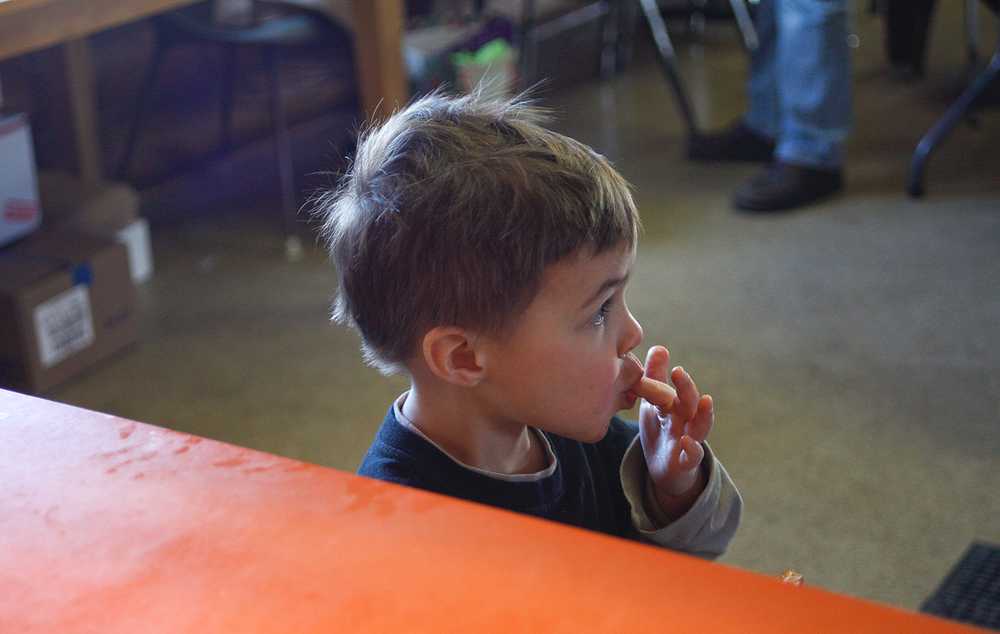 Photo by Rashah McChesney/Peninsula Clarion  Kash Bishop, 3, licks sugar off of his fingers as he eats a piece of fry bread Friday March 7, 2014 at Ft. Kenay in Kenai, Alaska.  Proceeds from the monthly "Fry Bread Fridays" benefit the Holy Assumption of the Virgin Mary Russian Orthodox Church.