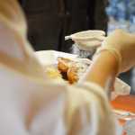 Photo by Rashah McChesney/Peninsula Clarion  Volunteer Dorothy Gray sprinkles powdered sugar on a stack of fry bread during "Fry Bread Friday" Friday March 7, 2014 at Ft. Kenay in Kenai, Alaska.