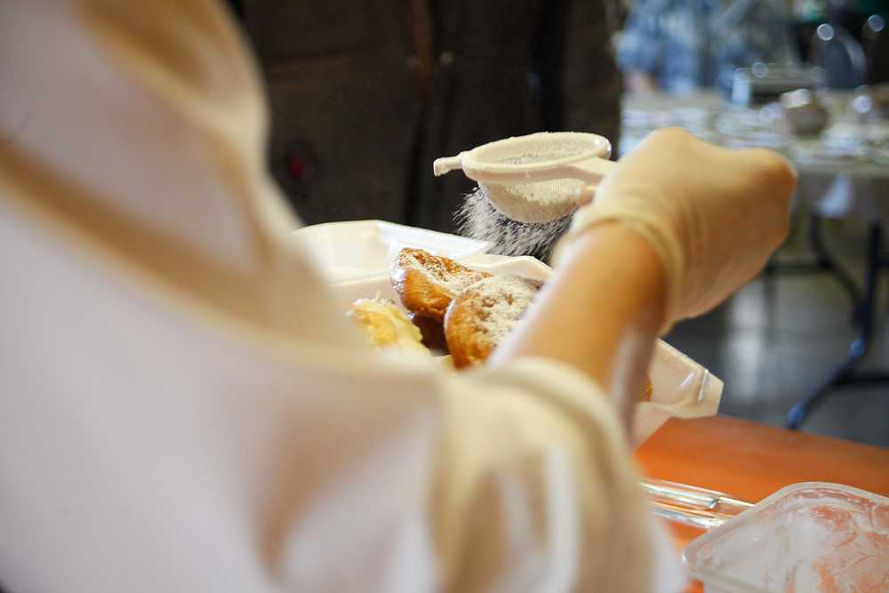 Photo by Rashah McChesney/Peninsula Clarion  Volunteer Dorothy Gray sprinkles powdered sugar on a stack of fry bread during "Fry Bread Friday" Friday March 7, 2014 at Ft. Kenay in Kenai, Alaska.