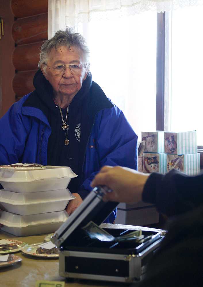 Photo by Rashah McChesney/Peninsula Clarion  Mary Lou Bottorf pays for her treats during "Fry Bread Friday" Friday March 7, 2014 at Ft. Kenay in Kenai, Alaska. Proceeds from the sale benefit the Holy Assumption of the Virgin Mary Russian Orthodox Church in Kenai.