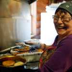 Photo by Rashah McChesney/Peninsula Clarion  Volunteer Lydia Pollard spent her afternoon cooking and joking with customers Friday March 9, 2014 during "Fry Bread Friday" at Ft. Kenay in Kenai, Alaska.