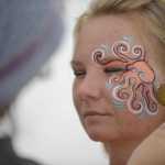 Photo by Rashah McChesney/Peninsula Clarion Danielle Rickard, of Ninilchik, gets an octopus painted on her face Friday August 2, 2013 during Salmonstock in Ninilchik, Alaska.