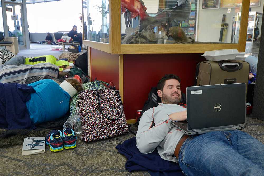 Photo by Rashah McChesney/Peninsula Clarion Andrew Spicher, of New York, messes around on his computer as he and several Alyeska-bound friends wait to leave the Kenai Municipal Airport Saturday March 15, 2014 in Kenai, Alaska.