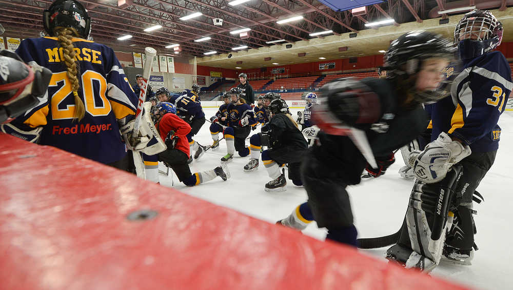 Photo by Rashah McChesney/Peninsula Clarion  The Kenai Peninsula Hockey Association girl's U16 team takes a knee during practice Friday March 14, 2014 at the Soldotna Sports Center in Soldotna, Alaska.
