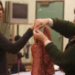 Photo by Kelly Sullivan/ Peninsula Clarion  Soldotna High School senior Emma Seldon and volunteer Maureen Mokracek examine a vintage-style dresss on Tuesday, March 18, at Cinderella's Closet.
