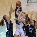 Nikiski senior Emily Lynch (22) scores over Valdez sophomores Mesa Rohrer and Madison Fleming and senior Rachel MacDonald (14) during their 3A girls consolation bracket game in the ASAA state high school basketball tournament at Anchorage's Sullivan Arena on Friday.