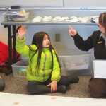 Photo by Kelly Sullivan/ Peninsula Clarion Olivia Davis and Claudia Martinez volunteer to answer one of  Leah Eskelin's scat and tracks riddles, Saturday, March 22, at the Wildlife seminar for WSTD.