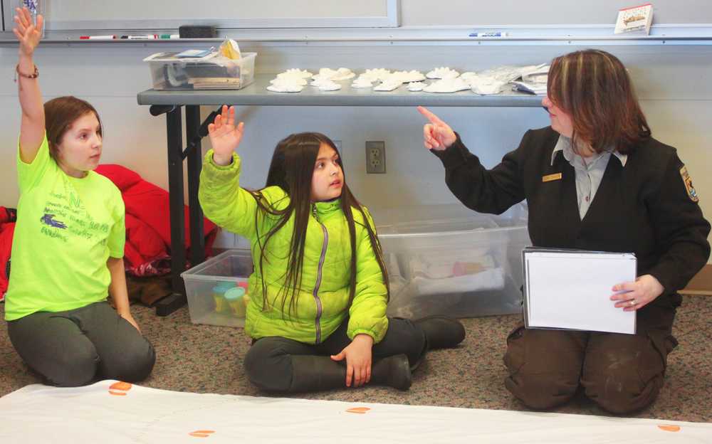 Photo by Kelly Sullivan/ Peninsula Clarion Olivia Davis and Claudia Martinez volunteer to answer one of  Leah Eskelin's scat and tracks riddles, Saturday, March 22, at the Wildlife seminar for WSTD.