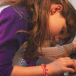 Ava Grossl works on her "Brushbot", the tiny robots Girl Scouts put together, Saturday, March 22, for Women of Science and Technology day at KPC.