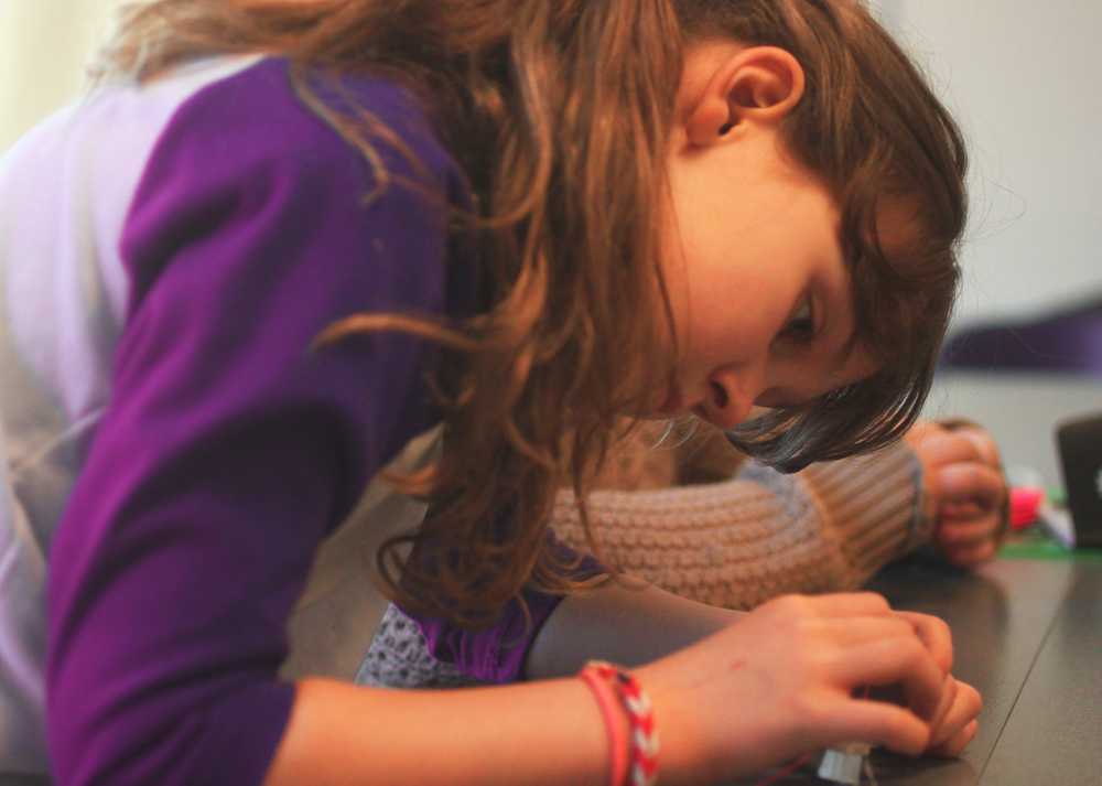 Ava Grossl works on her "Brushbot", the tiny robots Girl Scouts put together, Saturday, March 22, for Women of Science and Technology day at KPC.