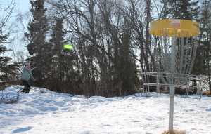 Connor Schoessler and Jarrett Urban watch as Bryan Hahn tees off on the Kenai Eagle Disc Golf Course Monday afternoon.
