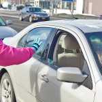 Photo by Rashah McChesney/Peninsula Clarion  Natalie Merrick, of Soldotna, waves to a passerby after giving the woman information on the Green Dot Alaska anti-violence campaign Tuesday April 8, 2014 in Soldotna, Alaska.
