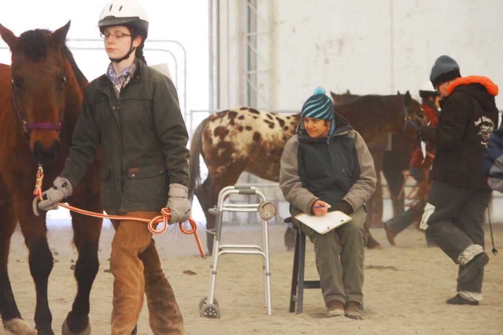 Photo by Kelly Sullivan/ Peninsula Clarion Sue Robinson, the judge for the 4H Horse Contest, had to sit during the competiton making it even harder to battle the morning temperatures, Friday, April 11, at the Solid Rock Bible Camp.