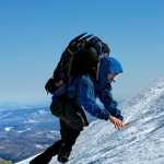 In this Friday, April 4, 2014 photo, Joe Murdzek scrambles up a snowfield while climbing Mount Adams in the Northern Presidential Range of the White Mountains in New Hampshire. Murdzek, 47, of East Hartford, Conn, and three high school friends have made a tradition of getting away on overnight climbing trips as a way to "hit the reset button" from the daily grind. (AP Photo/Robert F. Bukaty)