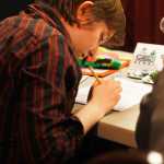 Photo by Kelly Sullivan/ Peninsula Clarion Kelly Trefon passes out t-shirt props during Skyview high school student Haley Trefon's presentation on The Sparrow Song at CFK, Thursday, April 17, at Kenai Central High School.