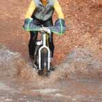 Photo by Kelly Sullivan/ Peninsula Clarion Doug Armstrong rode downhill into a muddy, pool of melting ice on Wolverine trail, Saturday, April 19, at the Tsalteshi Trail.