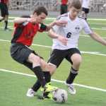 Houston's Aaron Drake battles Nikiski's Nathan Carstens for the ball during the Bulldogs' 4-0 win over the Hawks April 18 at Houston High School.