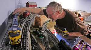 In this photo taken on Tuesday afternoon, April 15, 2014, Richard Oehrig swaps locomotives on the upper rail line of his model railroad he's building in a friend's warehouse in Fairbanks, Alaska. Oehrig spends his lunch hours laying railroad track and carefully gluing pieces of scale-size gravel along the tracks. Sometime he's so busy with his project that he doesn't eat.(AP Photo/Fairbanks Daily News-Miner, Eric Engman) MAGS OUT, NO SALES