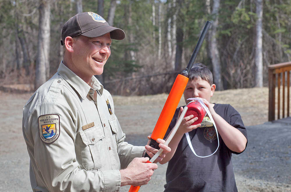 Photo by Rashah McChesney/Peninsula Clarion  U.S. Fish and Wildlife refuge operations sepcialist Dave Bolin demonstrates how he would check a shotgun during a role-playing session on law enforcement as Rocky Sherbahn takes a sip of his water Saturday May 3, 2014 during a Youth Game Warden camp at the Kenai National Wildlife Refuge Headquarters in Soldotna, Alaska.