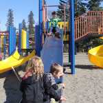 Photo by Dan Balmer/Peninsula Clarion Cooper Every, 4, sits at the top of the slide while Gracce Every, 5, and Carson Cramer sit at the bottom of the slide at Municipal Park Thursday. The three are playing on equipment intended for the 5-12 age group. A group of Kenai moms are working with the parks and recreation commission on a proposal that would include a new playgroud for toddlers and older kids.