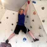 Photo by Dan Balmer/Peninsula Clarion Hunter Sundberg, 11, looks to get his footing on a rock wall built in the garage of Natalie and Nic Larson in Soldotna. The Larson's started teaching rock climbing sessions to several kids in March and are accepting new students for summer sessions beginning June 9.