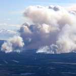 Photo by Kelly Sullivan/Peninsula Clarion Megan Schaafsma stopped on the Sterling Highway near Kasilof Tuesday to watch the smoke plumes from a wildfire that started near Funny River Monday evening.