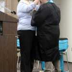 River City Academy Principal Dawn Edwards-Smith adjusts graduate Shelby Fletcher's mortarboard one last time after knocking it off during a hug at the school's graduation ceremony at the Soldotna Regional Sports Complex on Wednesday. Photo by Kaylee Osowski/Peninsula Clarion