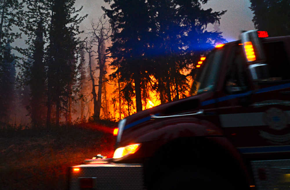 Photo by Rashah McChesney/Peninsula Clarion A firetruck provides water for crew on the ground as firefighters backburned near Funny River Road Wednesday May 21, 2014 in Soldotna, Alaska. Fire crews have been battling a wildfire that has grown to more than 44,000 acres in three days.