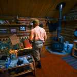 Photo by Rashah McChesney/Peninsula Clarion  Erik Huebsch clears debris from a pump settled into Tustumena Lake where it provides water to his remote access cabin Friday May 23, 2014 in the Kenai National Wildlife Refuge.  Huebsch and several other homeowners have watched as the Funny River Horse Trail wildfire has burned within a mile of their cabins on Bear Creek.