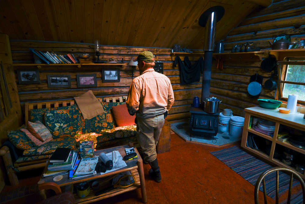 Photo by Rashah McChesney/Peninsula Clarion  Erik Huebsch clears debris from a pump settled into Tustumena Lake where it provides water to his remote access cabin Friday May 23, 2014 in the Kenai National Wildlife Refuge.  Huebsch and several other homeowners have watched as the Funny River Horse Trail wildfire has burned within a mile of their cabins on Bear Creek.