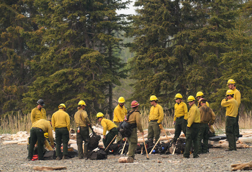 Photo by Rashah McChesney/Peninsula Clarion  Erik Huebsch shows the cabin where he and his wife stay when they visit their acreage in the remote Bear Creek subdivision along the shores of Tustumena Lake Friday May 23, 2014 in the Kenai National Wildlife Refuge. Several homeowners were on hand trying to firewise their property as the Funny River Horse Trail wildfire burned less than a mile from the subdivisions. The wildfire has consumed close to 70,000 acres of refuge land.
