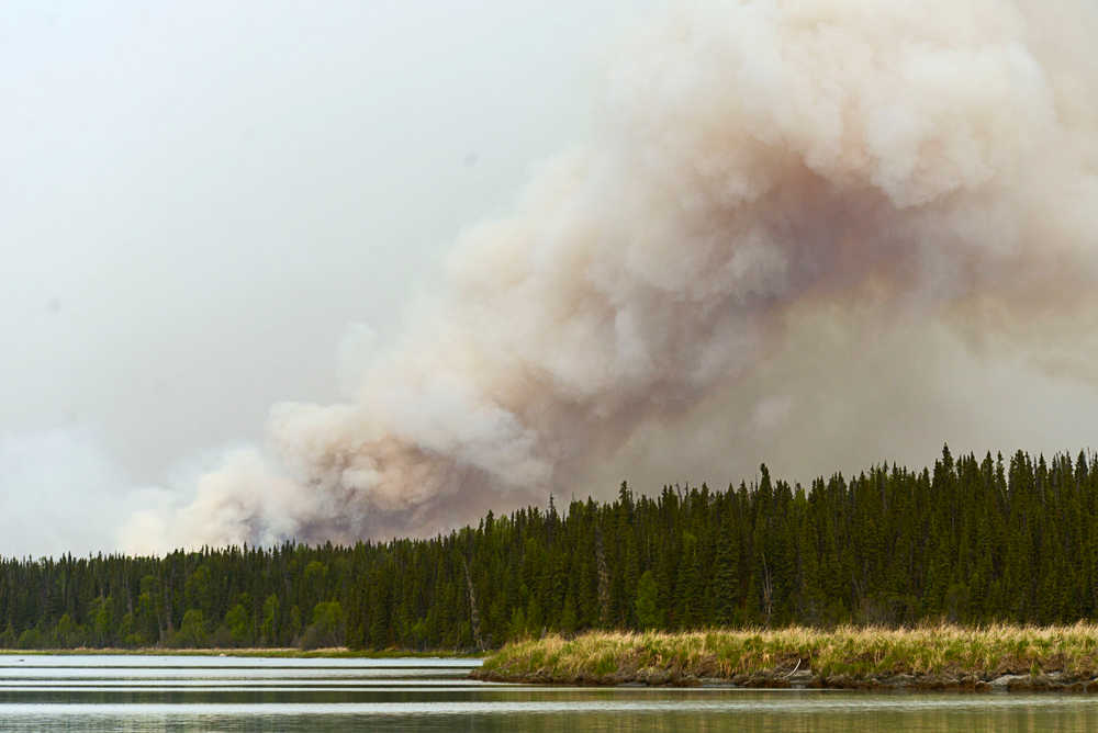 Photo by Rashah McChesney/Peninsula Clarion  A team of firefighters stands on the north shore of Tustumena Lake near the Bear Creek remote access subdivision Friday May 23, 2014 in the Kenai National Wildlife Refuge. Crews said the nearly 70,000 acre Funny River Trail wildfire was burning within a mile of the cabins and several homeowners were hand to pump water onto their properties.