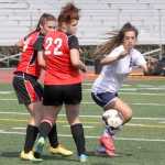 Soldotna's Reagan Schoessler tries to move the ball around Kenai's Sarah Every (24) and Caitlin Steinbeck (22) during a 5-0 win over the Kards.