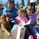 Lucy, a certified therapy dog, and her handler, Katie Moon (left), listen to kindergartener Maria Kratsas (center) and fourth grader Isabella Rodriguez (right) read on Tuesday, May 20, at Kalifornsky Beach Elementary School in Soldotna. Photo by Kaylee Osowski/Peninsula Clarion