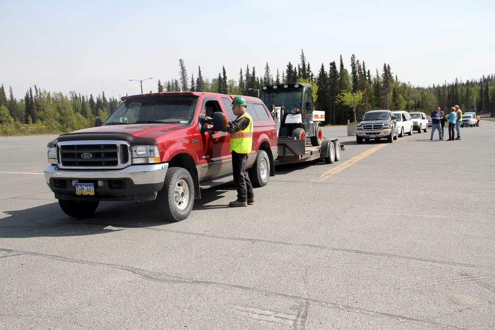 Victor Hett with the Kenai Peninsula Borough Community Emergency Response Team assists an evacuee from the Funny River Road area on Sunday at the Soldotna Regional Sports Complex. The Borough Office of Emergency Response asked residents from Mile 7 to Fisherman's Road to evacuate Sunday afternoon. Photo by Kaylee Osowski/Peninsula Clarion