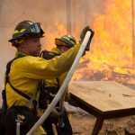 Photo by Rashah McChesney/Peninsula Clarion Central Emergency Services firefighter Dan Jensen maneuvers a hose into position to fight a portion of the 156,041 acre Funny River Horse Trail wildfire Sunday May 25, 2014 in the Funny River community of Soldotna, Alaska.