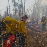 AP Photo/Peninsula Clarion, Rashah McChesney  Central Emergency Services firefighter Terry Bookey laughs as his crew are showered with foam while fighting the Funny River Horse Trail wildfire Sunday May 25, 2014 in the Funny River community in Soldotna, Alaska. Several firefighting crews have been working to keep the 156,041 acre wildfire from encroaching into the more than 1,000 homes  in Funny River which was evacuated Sunday afternoon.