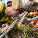 Photo by Rashah McChesney/Peninsula Clarion  Central Emergency Services firefighter Jake Lamphier lights a small brush pile on fire as his crew works to clear potential fuel from a fire line on Funny River Road Tuesday May 27, 2014 in Soldotna, Alaska. Nearly 700 firefighters and support personnel travelled to the Kenai Peninsula to keep the Funny River Horse Trail wildfire from overtaking communities in the area. The most recent maps show the fire to have burned 182,209, or 285 square miles, of Kenai Peninsula Wildlife Refuge land.