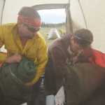 Photo by Rashah McChesney/Peninsula Clarion Firefighters Tim Kulinich and Bogdan Kulikovskiy unpack their bags inside of a tent in the soccer field Monday May 26, 2014 at Skyview High School in Soldotna, Alaska. More than 670 firefighting crew have arrived on the Kenai Peninsula to help combat the 170,000 acre Funny River Horse Trail wildfire.