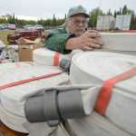 Photo by Rashah McChesney/Peninsula Clarion  (left) Scott Johnson, of Ninilchik, and Tom Vangs, of Oregon, stack firehouse on a pallet in the temporary warehouse set up to supply firefighters working on the Funny River Horse Trail wildfire Friday May 30, 2014 in Soldotna, Alaska.