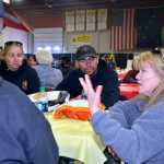 Photo by Dan Balmer/Peninsula Clarion Soldotna resident Lisa Lybrand thanks Fhurer Orejuela and other members of the Wolf Creek Hotshots at the appreciation dinner at the Soldotna Regional Sports Complex Sunday. More than 1,500 hamburgers and another 1,500 hot dogs were served up to firefighters and community residents.