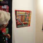 Photo by Dan Balmer/Peninsula Clarion Marilyn Kay Johnson looks at her quilt, "Road Trip" at the Kenai Fine Arts Center Wednesday. Johnson hand-made the quilt while driving back to Alaska from Arizona. It took her two weeks to complete and worked on it in the front seat of the car, and on the ferry from Bellingham, WA to Whittier.